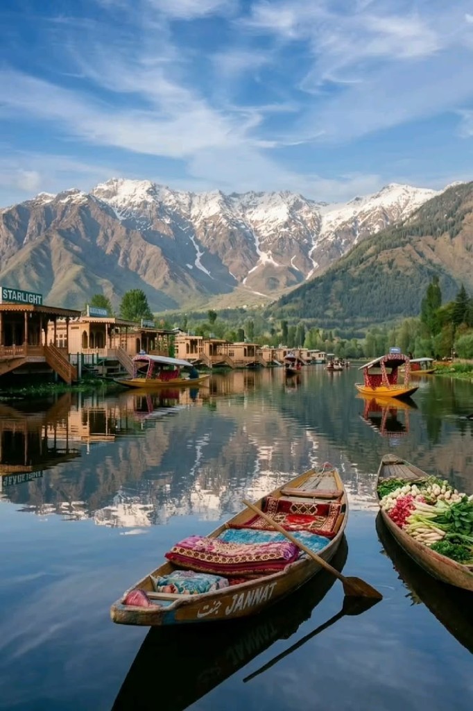 Shikara boats on Dal Lake with houseboats and snow-capped mountains in Jammu and Kashmir